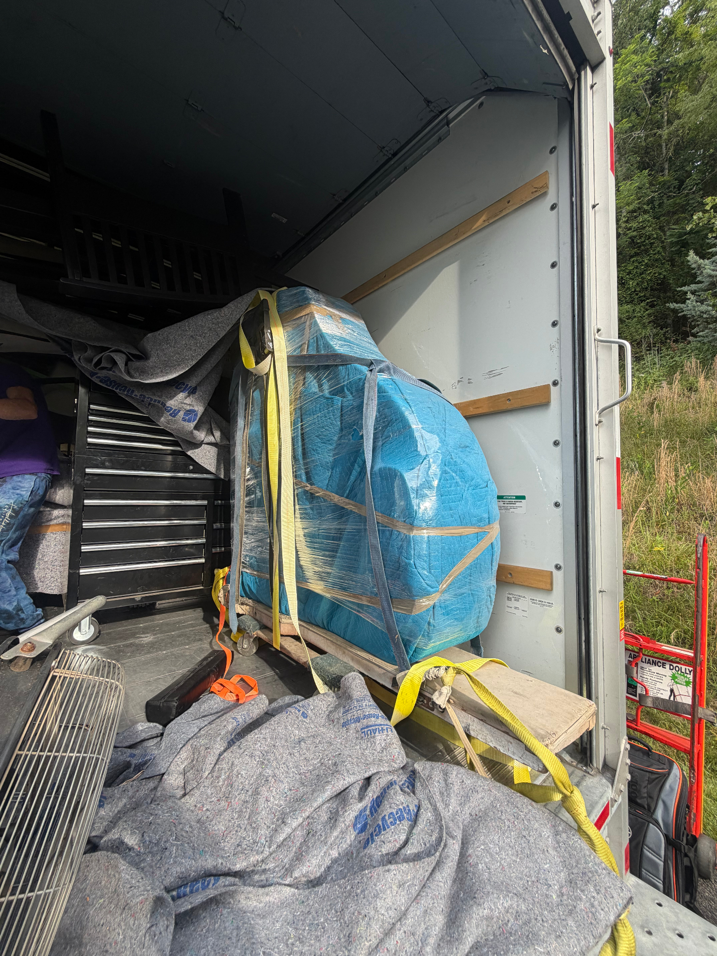 Blue-wrapped furniture strapped securely inside the V-Haulers truck