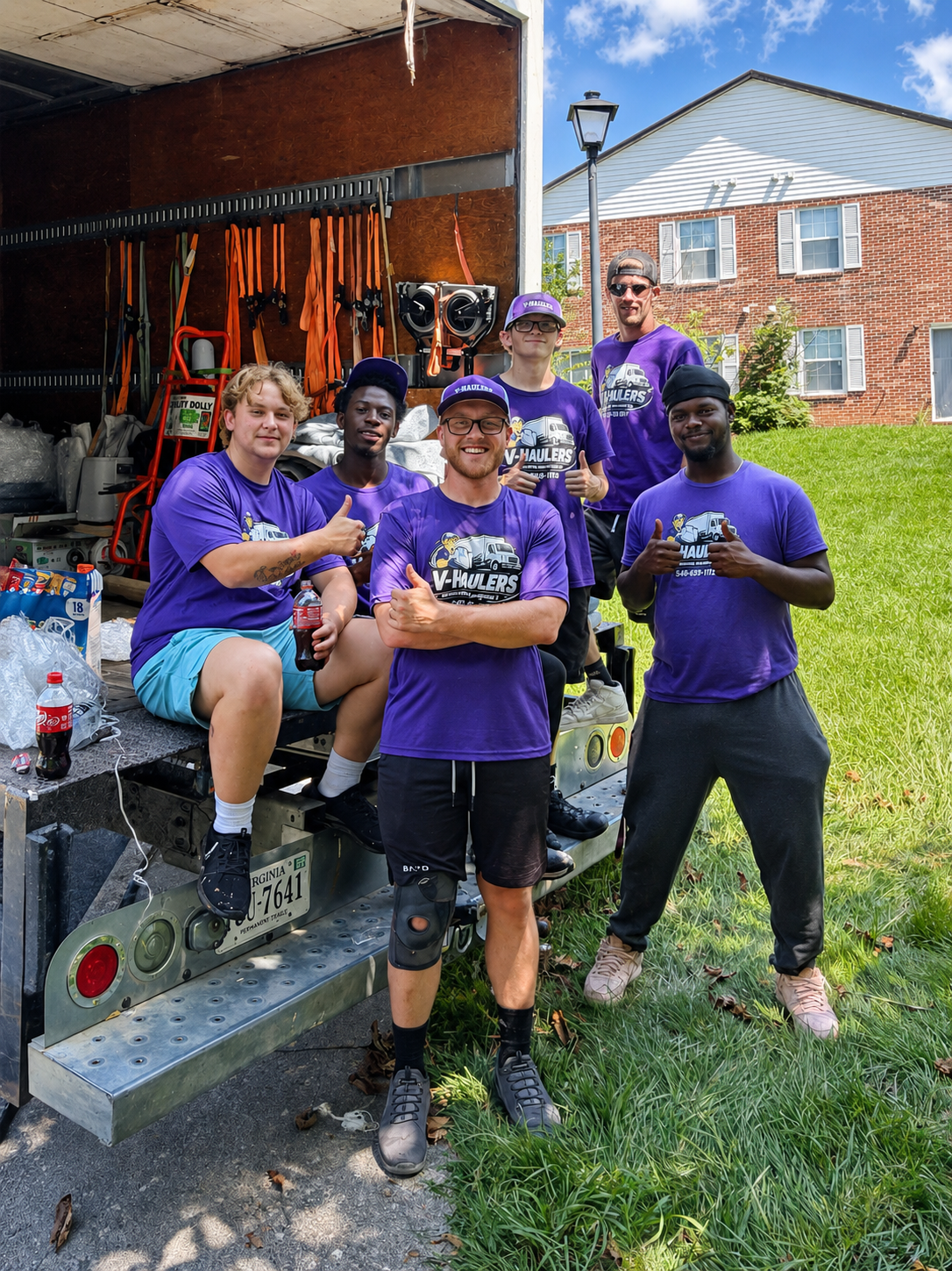 The V-Haulers crew giving a thumbs up beside their loaded moving truck
